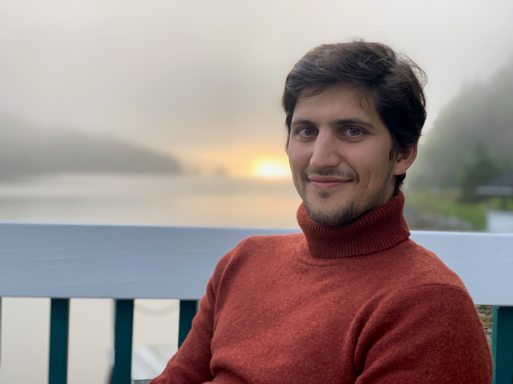 blurry photo of sunset over ocean with logo on top